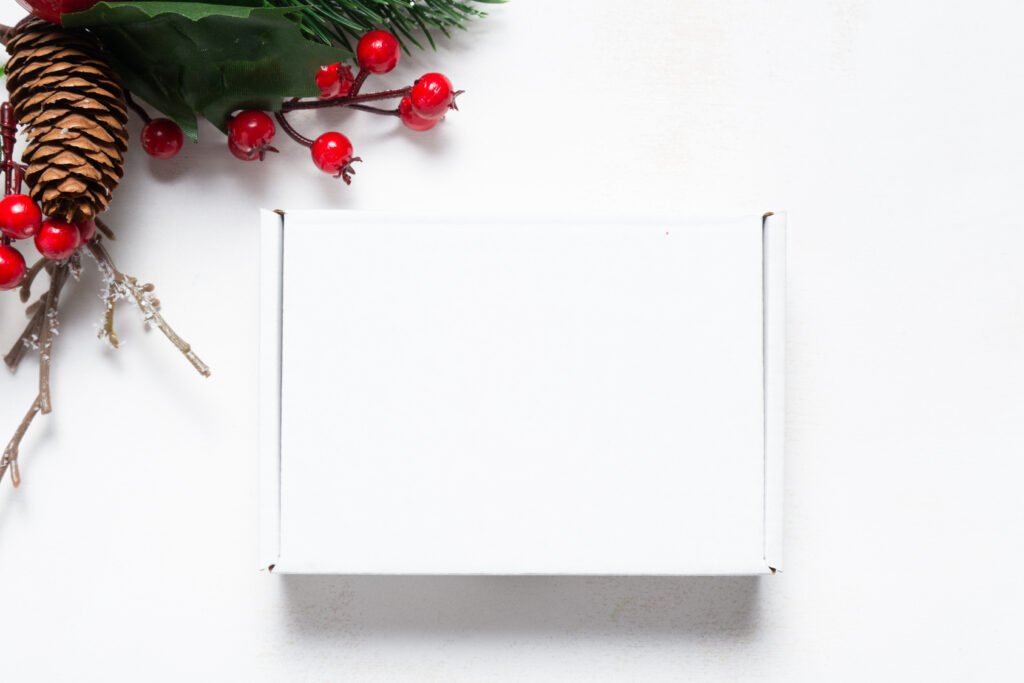 Brown cardboard shipping box decorated with Christmas ornaments, representing a holiday gift ready to mail before the 2026 shipping deadlines