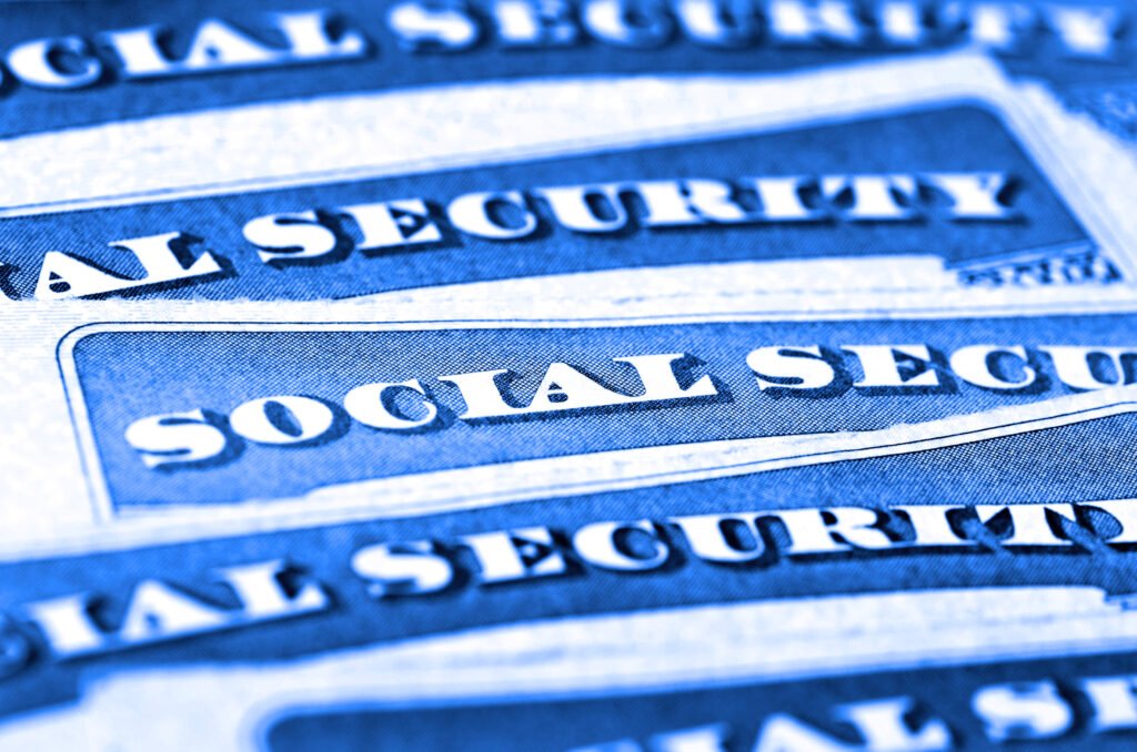Social Security cards next to cash, representing the 2027 cost-of-living adjustment for retirement benefits
